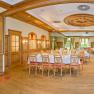 Elegant, wood-paneled dining room with set tables and large windows.