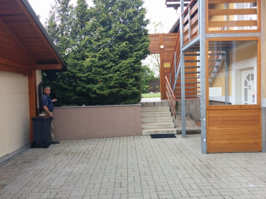 Hof mit Panoramatreppe und Mann neben Mülltonne.