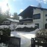 Snow-covered house with 'Pension Almboden' sign in the foreground.