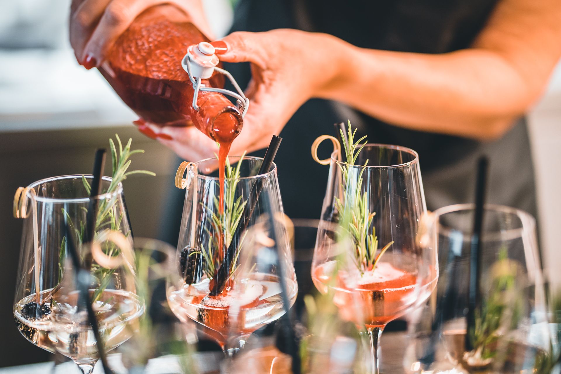 In schön dekorierte Gläser wird ein rotes Getränk eingeschenkt. 
