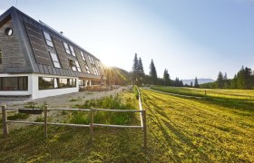 Naturfreundehaus Knofeleben in a sunny mountain landscape with solar panels on the roof.