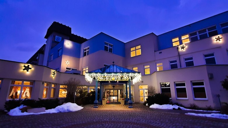 Illuminated building at dusk with Christmas decorations.
