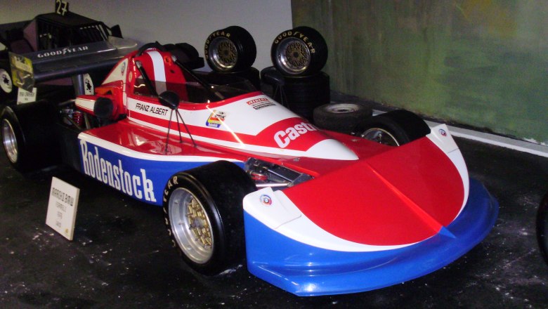 Ein rotes und weißes Rennfahrzeug mit der Aufschrift 'Rodenstock' im Automobilmuseum Aspang.