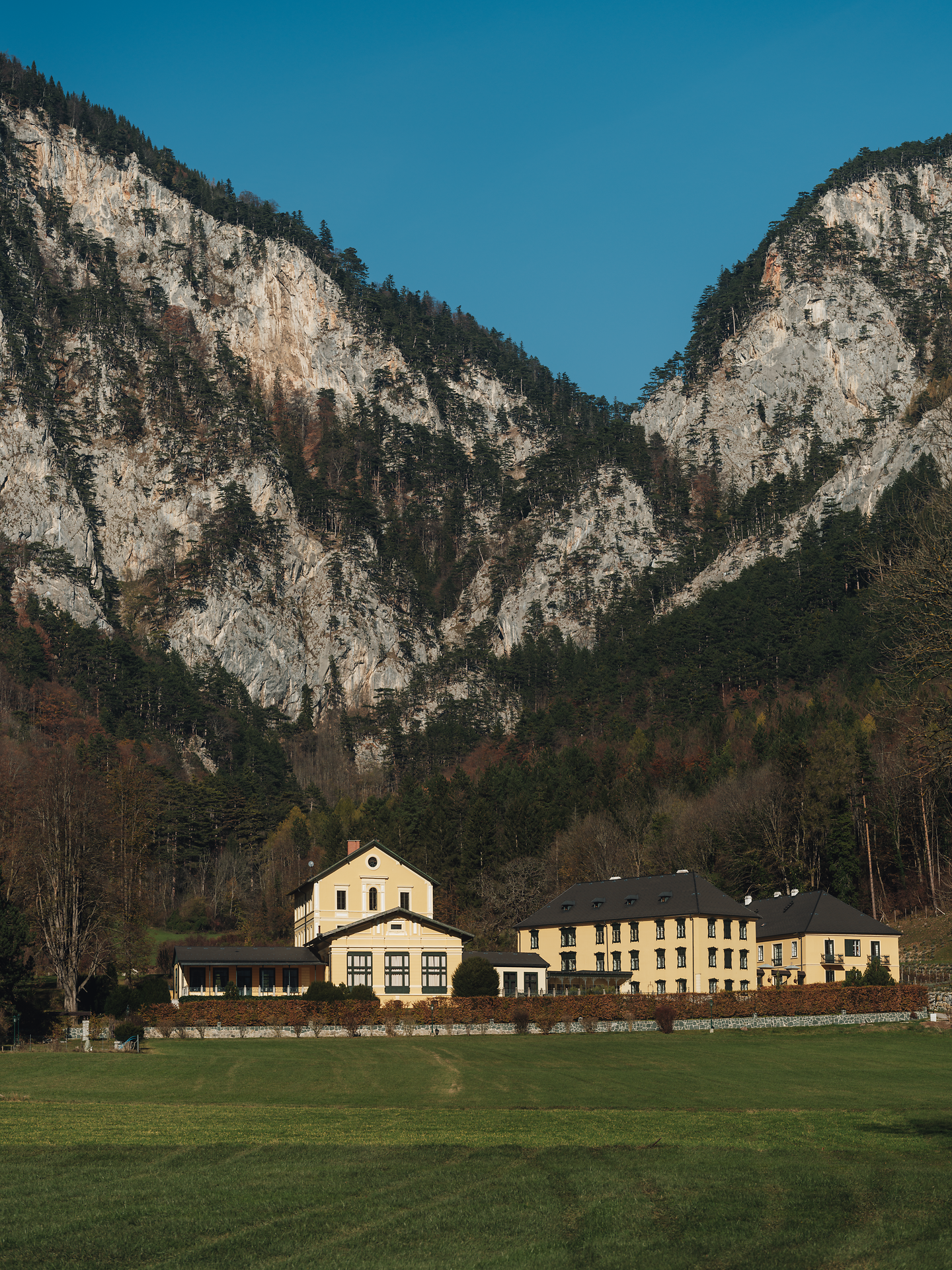 Umgeben von majestätischen Bergen strahlt die Landschaft eine friedliche Ruhe aus. Die sanften Wiesen laden zum Verweilen ein und bieten einen perfekten Blick auf die beeindruckenden Felsformationen. Hier kann man die frische Bergluft genießen und die Schönheit der Natur in vollen Zügen erleben.