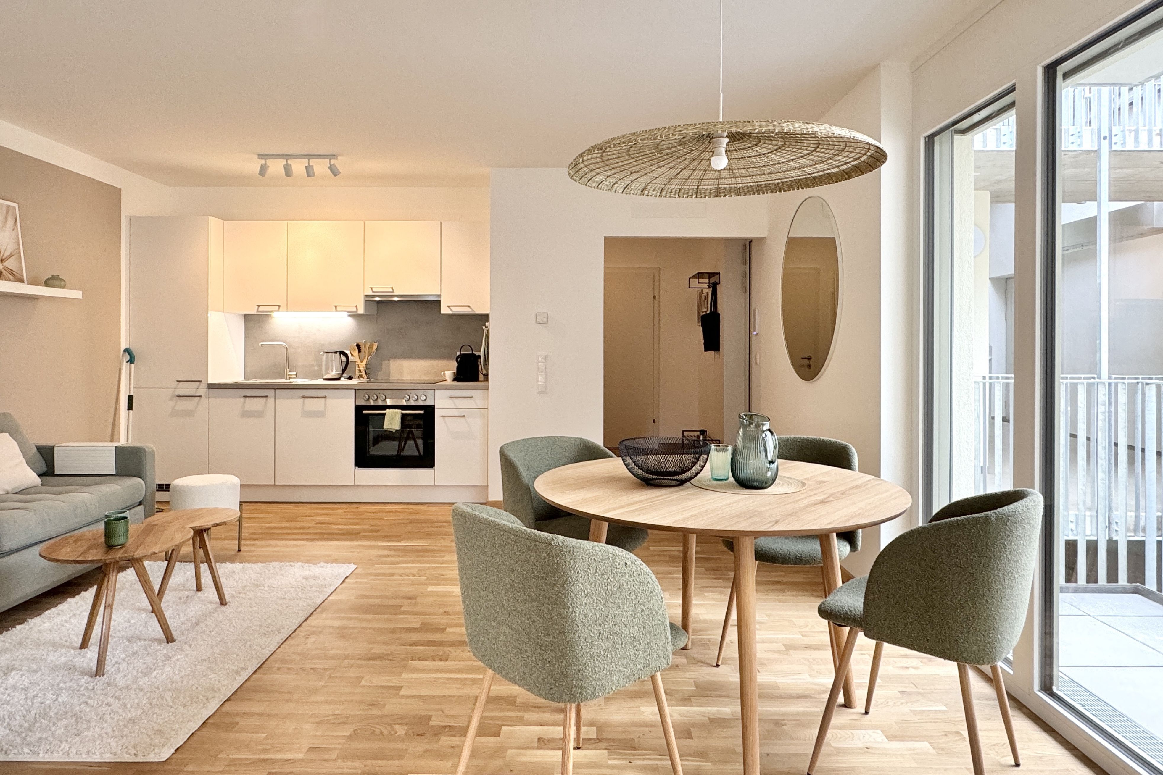 Ess- und Wohnbereich mit Küchenzeile, Esstisch, Couch und Balkon
