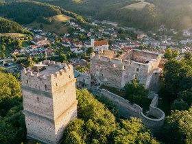 Luftaufnahme mit Feuerturm, Burgruine und dem Ort Kirchschlag, © Wiener Alpen, Roman Königshofer