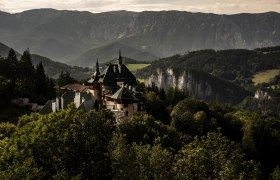 View of a historic hotel surrounded by mountain scenery