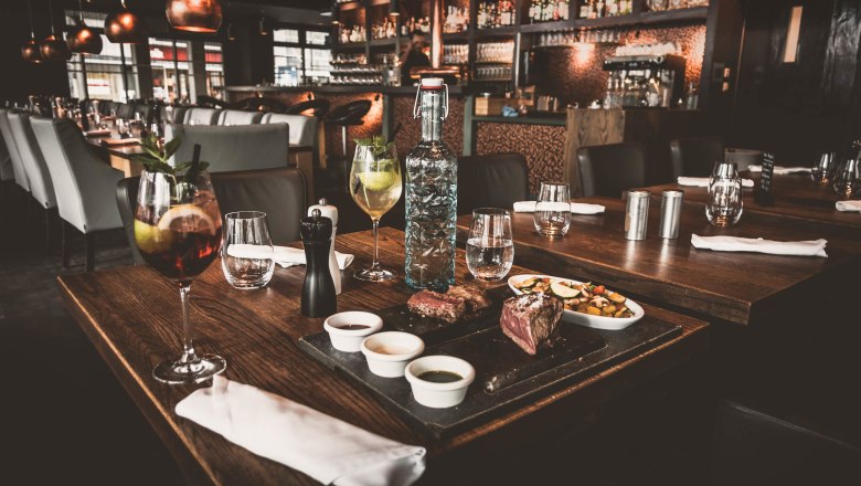 Elegantes Restaurant mit gedecktem Tisch, Getränken und Speisen.