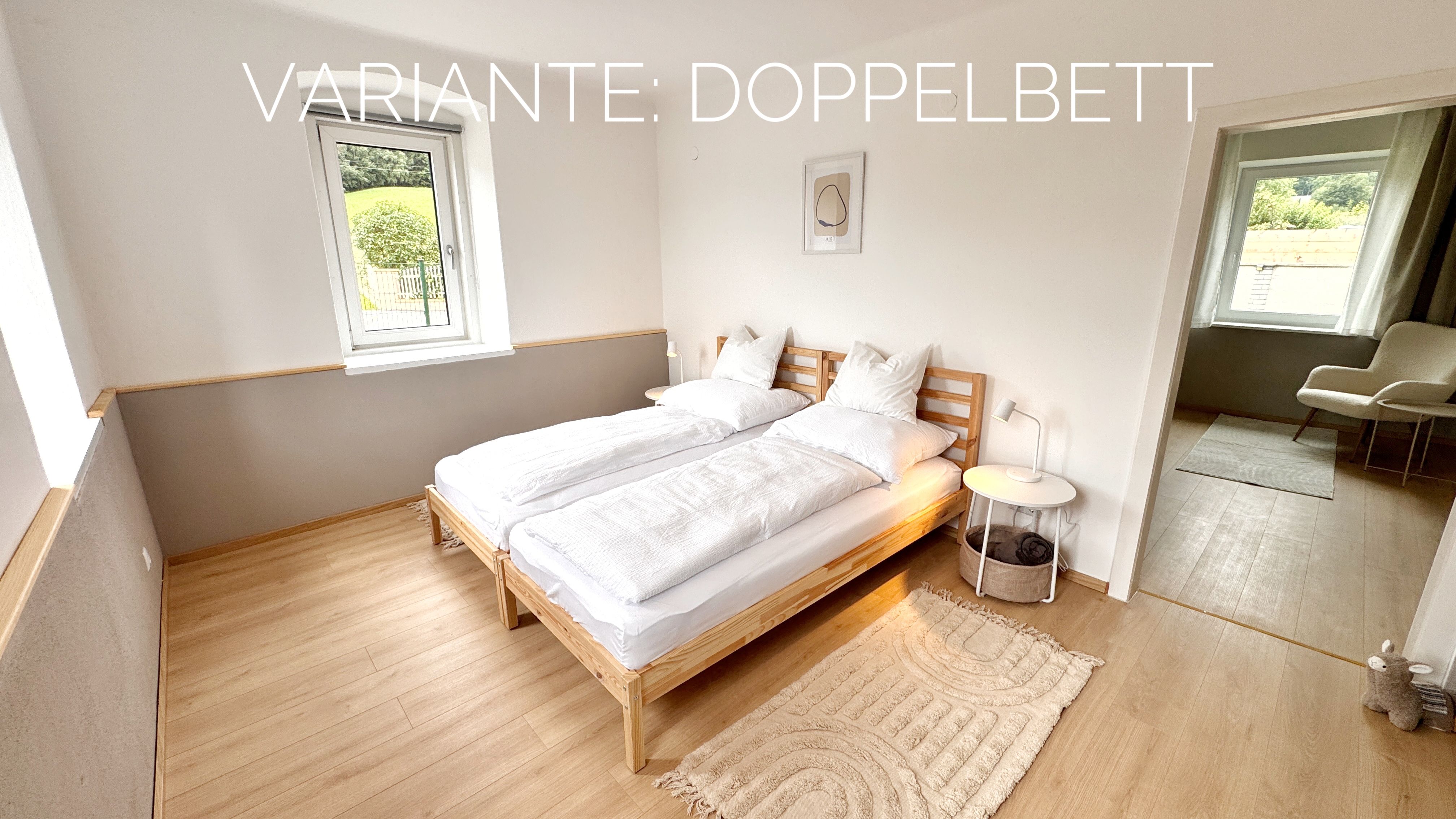 Modernes Schlafzimmer mit Doppelbett, Holzboden und Fenster mit Blick nach draußen.