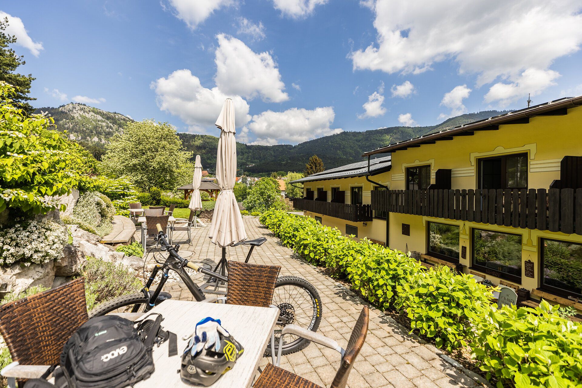Rückansicht des Landgasthof „Zur Schubertlinde“ mit Terrasse, Rad und Radzubehör auf dem Tisch