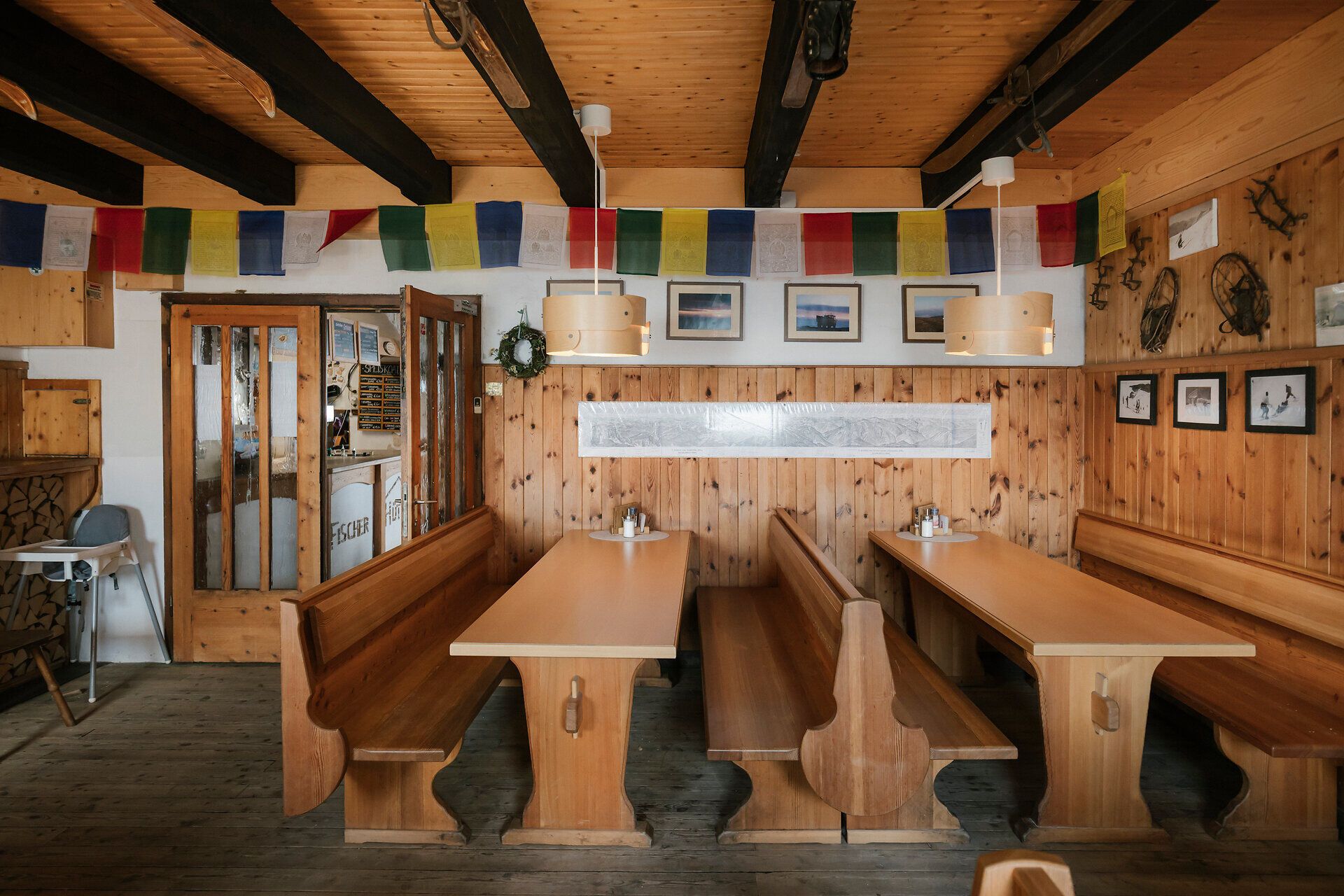 Gemütliche Gaststube der Fischerhütte am Schneeberg mit Holztischen, Bänken und traditioneller Einrichtung