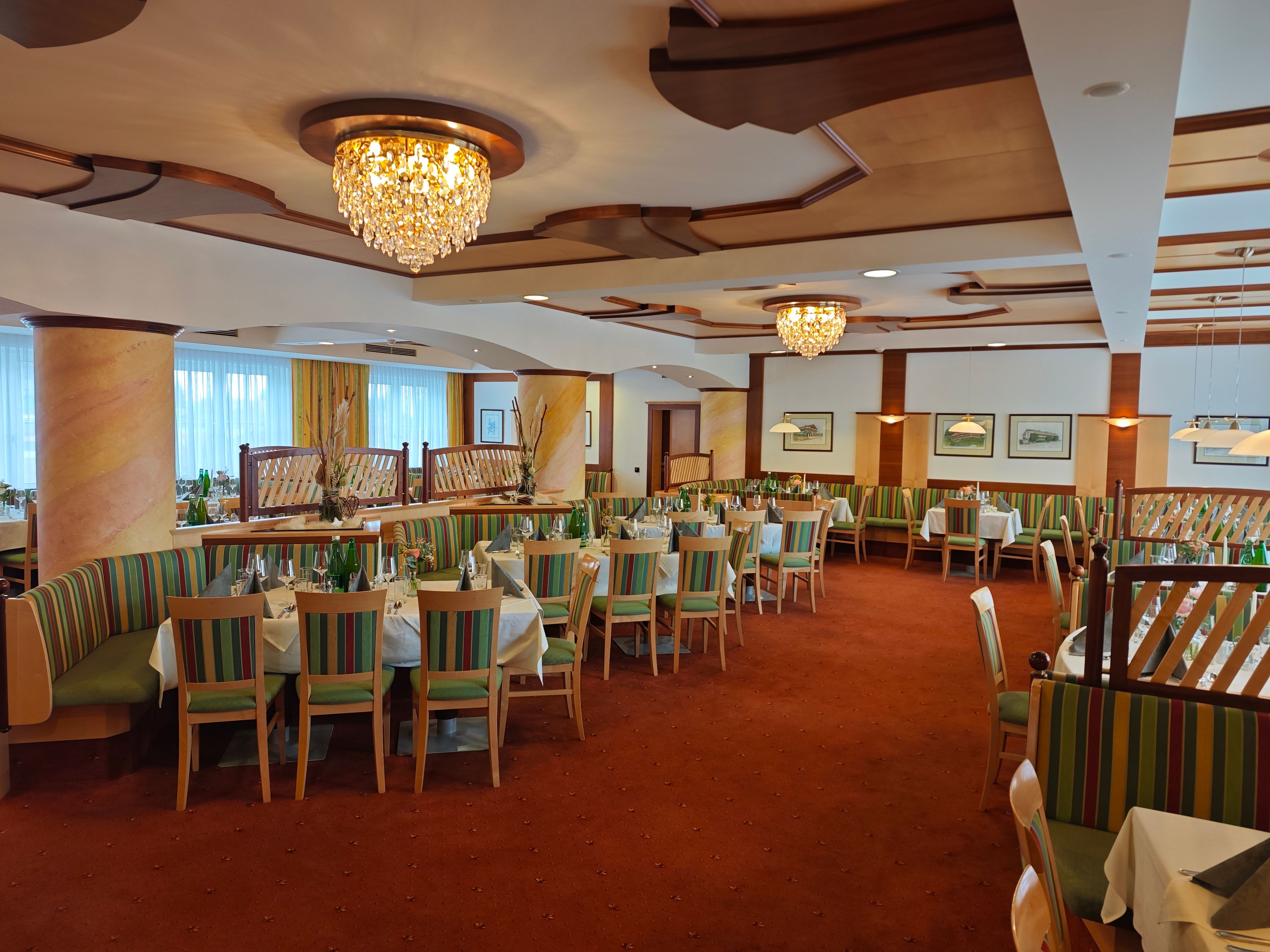 Eleganter Speisesaal mit Kronleuchtern und gedeckten Tischen im Hotel Thier.