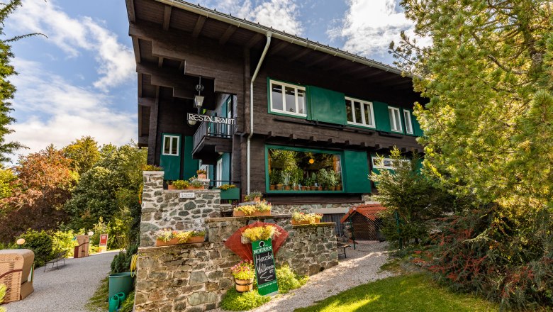 Looshaus am Kreuzberg, ein traditionelles Gebäude mit Restaurant, umgeben von Bäumen und Garten.
