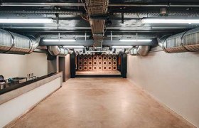 Innenansicht einer modernen Halle mit sichtbaren Lüftungsrohren.