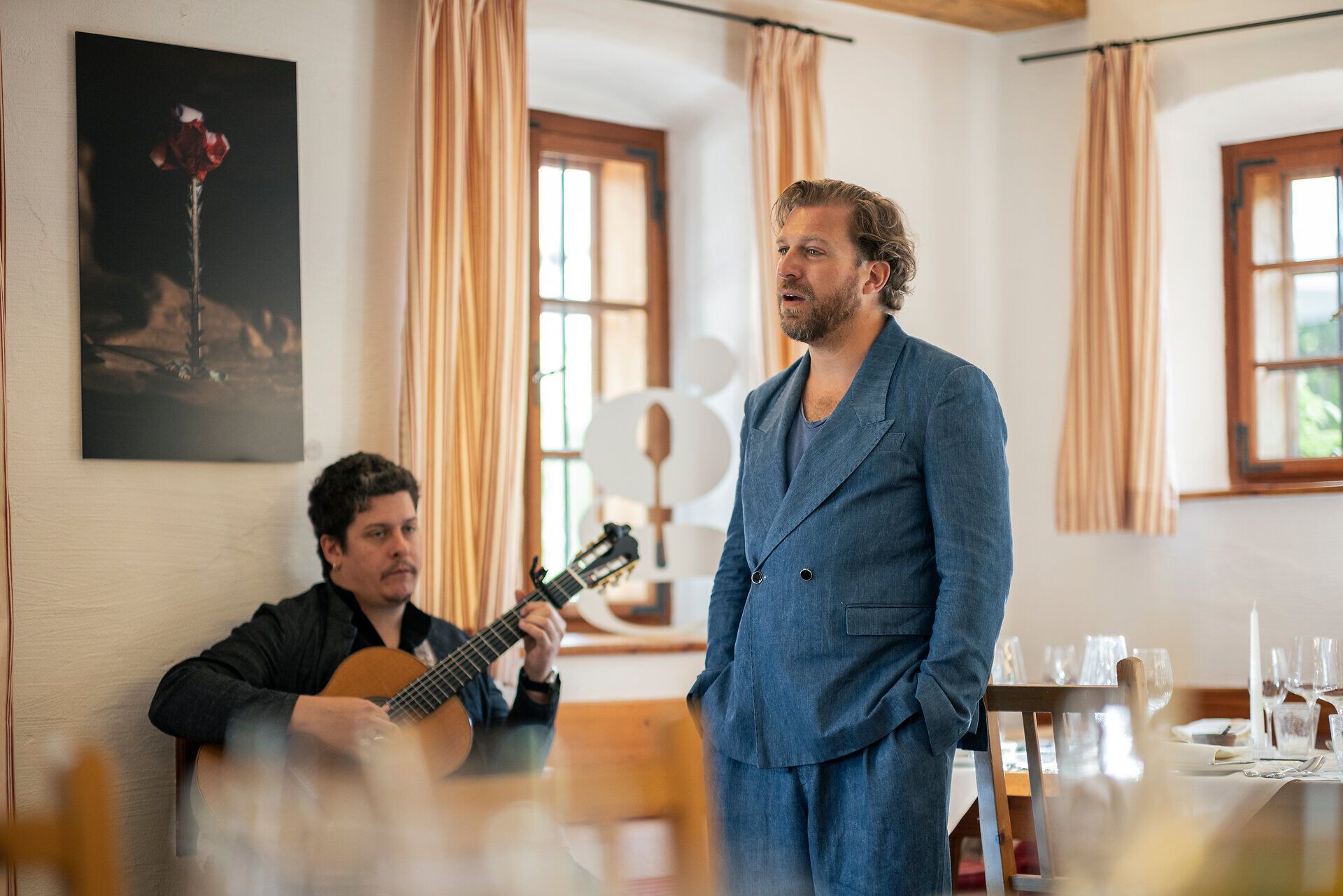 Der Tenor Julian Prégardien singt für die Gäste im Triad. Begleitet wird er von einem Mann mit einer Gitarre.