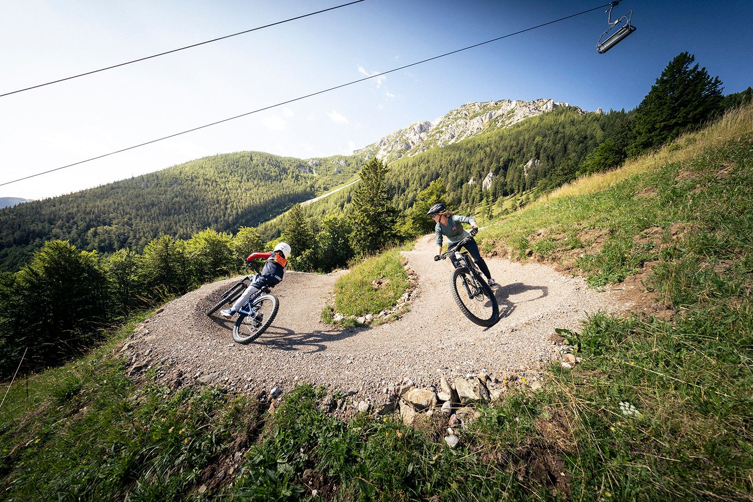 zwei Biker in einer Kurve des Alpen Bikepark Schneeberg