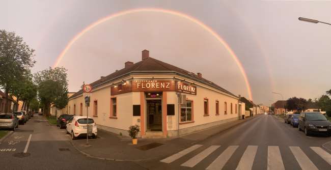Außenansicht des Gebäudes des Ristorante Florenz mit Regenbogen am Himmel.