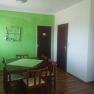 Dining area with green-painted wall, wooden table and chairs.