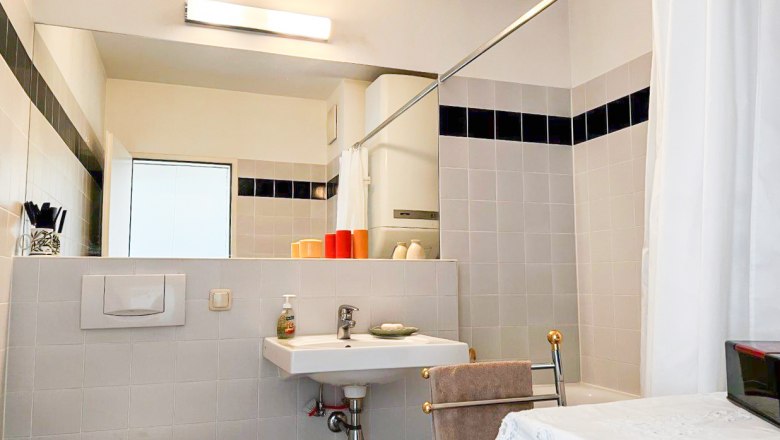 Modernes Badezimmer mit Waschbecken, Spiegel, Toilette und Dusche.