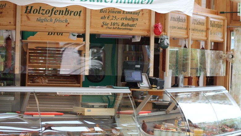 Innenansicht eines Bauernladens mit Theke und Holzofenbrot.