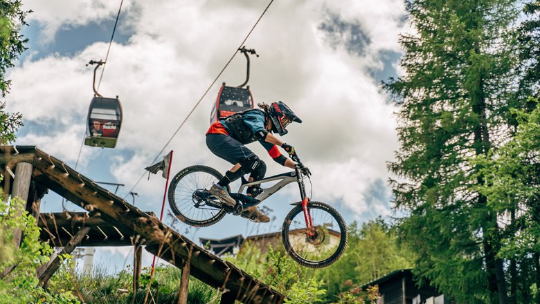 Mountainbiker springt von Rampe im Bikepark Semmering.