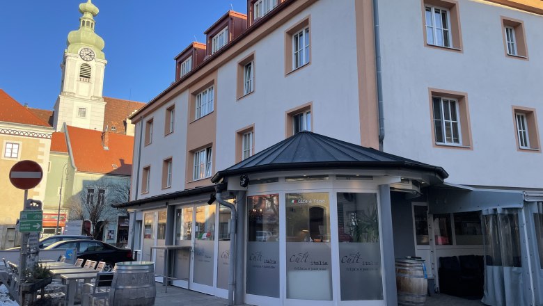 Außenansicht eines Restaurants mit der Aufschrift 'Cult Italia' und einem Kirchturm im Hintergrund.