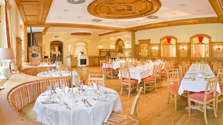 Elegant ballroom with laid tables and wooden furnishings.