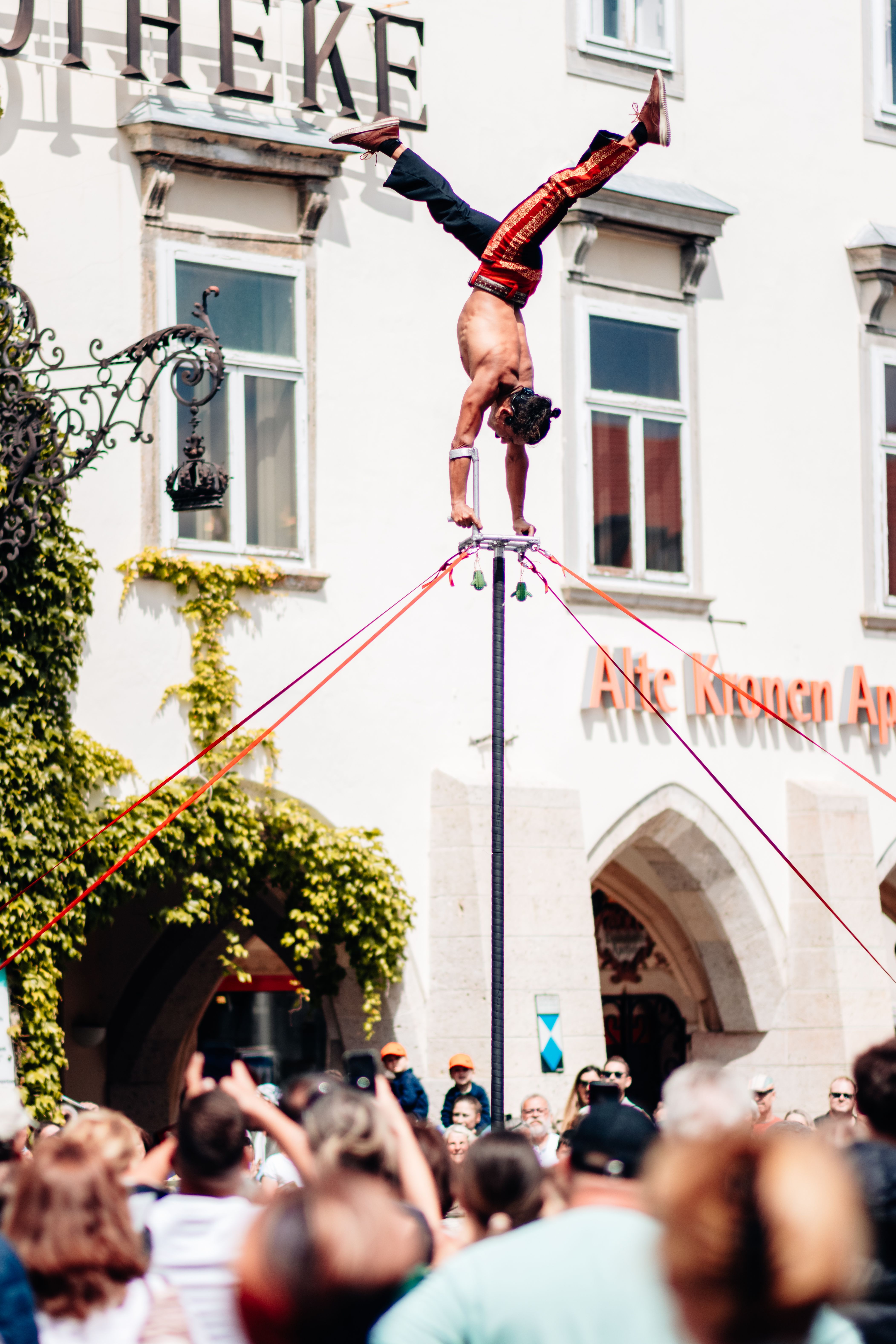 Akrobat tanzt auf einem Stab in der Innenstadt von Wiener Neustadt. 