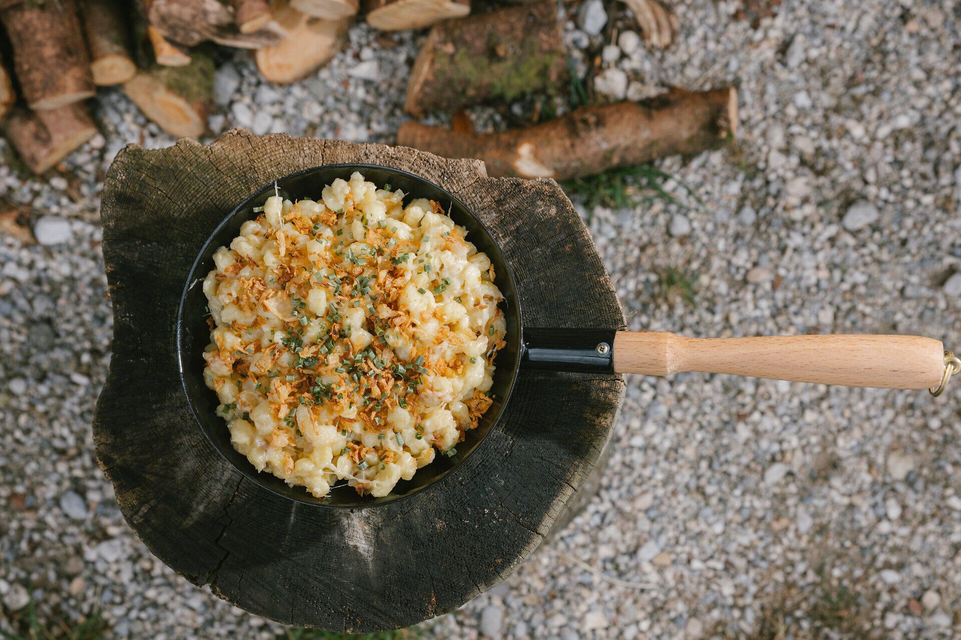 Käsespätzle in einer Pfanne mit Röstzwiebeln und Kräutern