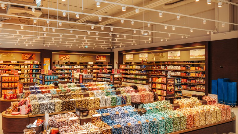 Ein großer Süßwarenladen mit bunten Pralinen und Schokoladenregalen.