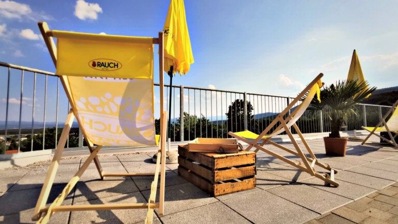 Sun loungers and parasols on a terrace with a view.