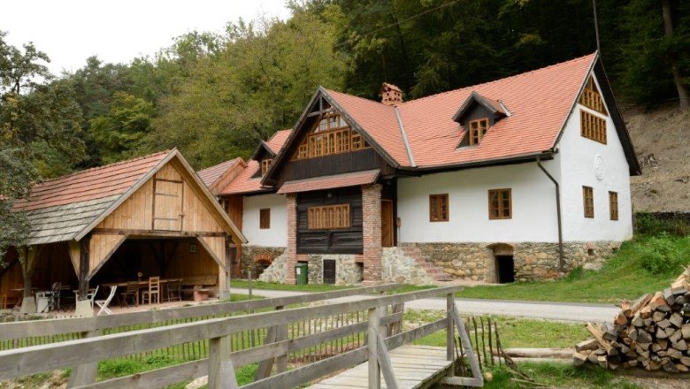Traditionelles Haus mit rotem Dach und Holzdetails in ländlicher Umgebung.