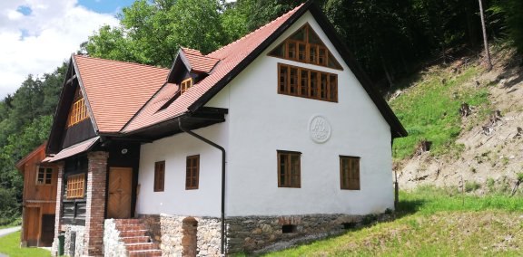 Traditionelles Haus mit rotem Dach in ländlicher Umgebung.