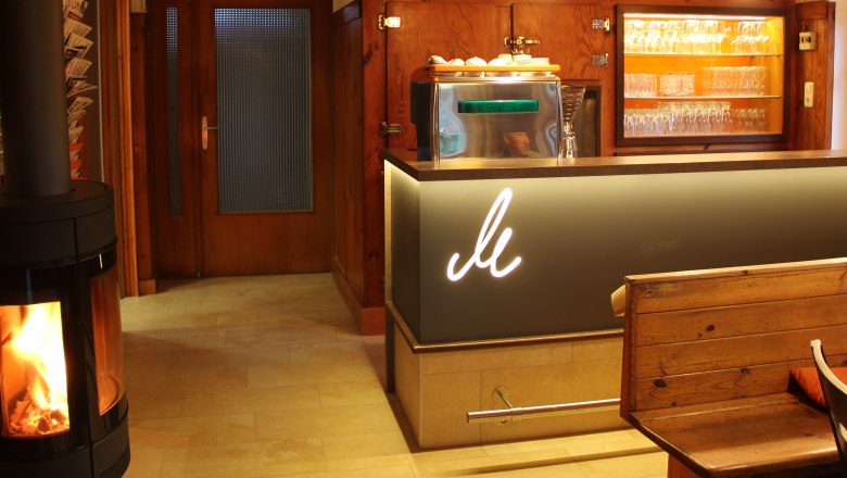 Gemütliche Bar mit Holzdekor, Kamin und Gläsern.