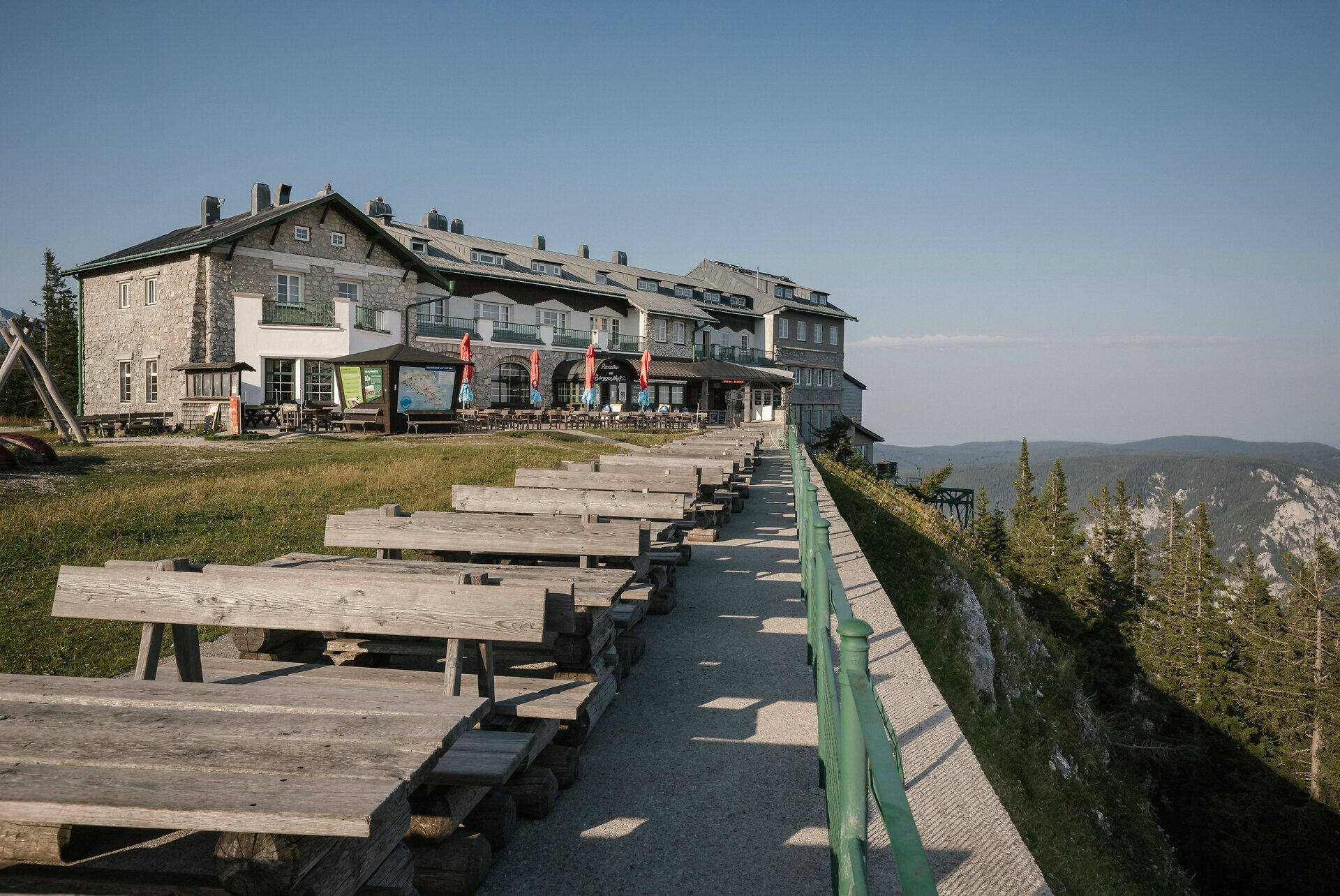 Raxalm-Berggasthof mit Sitzbänken entlang der Aussichtsterrasse