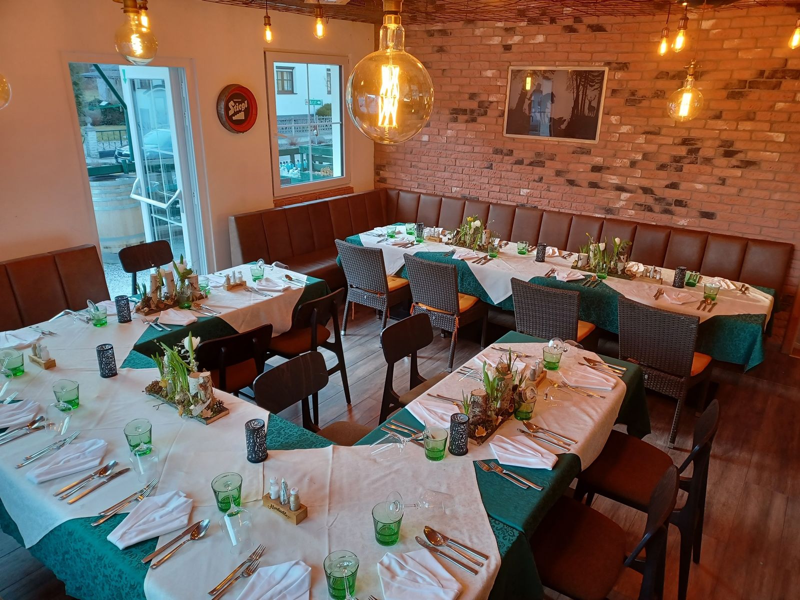 Gemütliche Gaststube mit gedeckten Tischen und Dekoration für eine Feier.