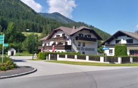 Ein Café-Restaurant in einer ländlichen Gegend mit Bergen im Hintergrund.