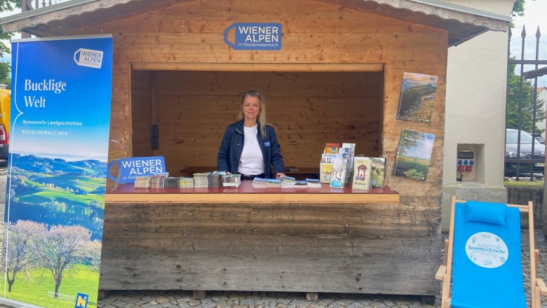 H&uuml;tte mit Prospektmaterial und Mitarbeiterin der Wiener Alpen