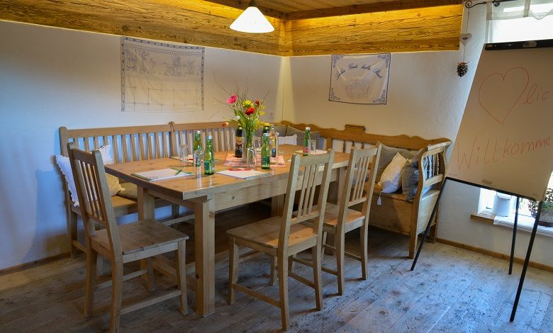 Gemütlicher Seminarraum mit Holztisch, Stühlen und Flipchart.