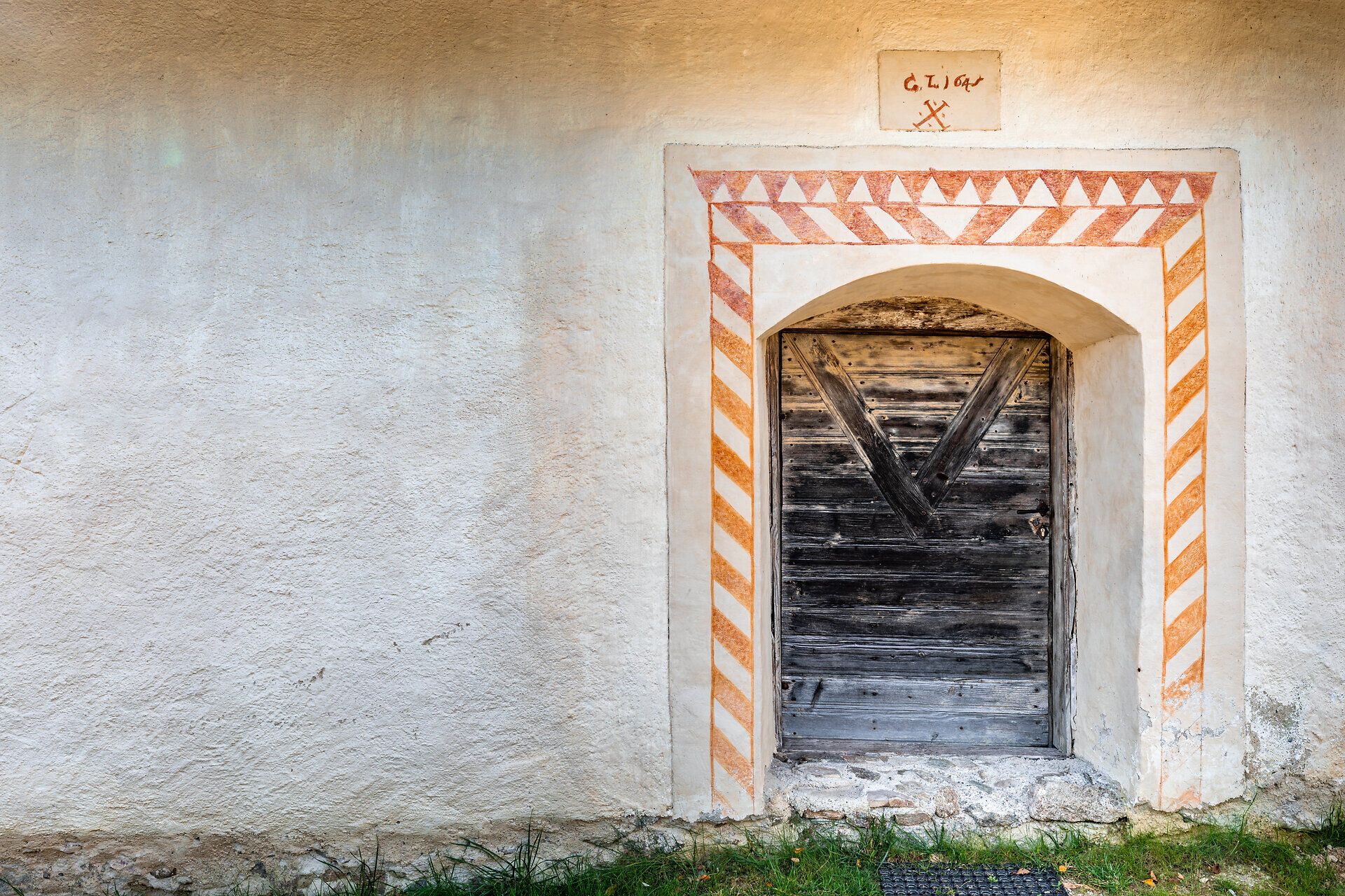 Eine Holztür mit gemaltem Türstock gebaut in eine Mauer