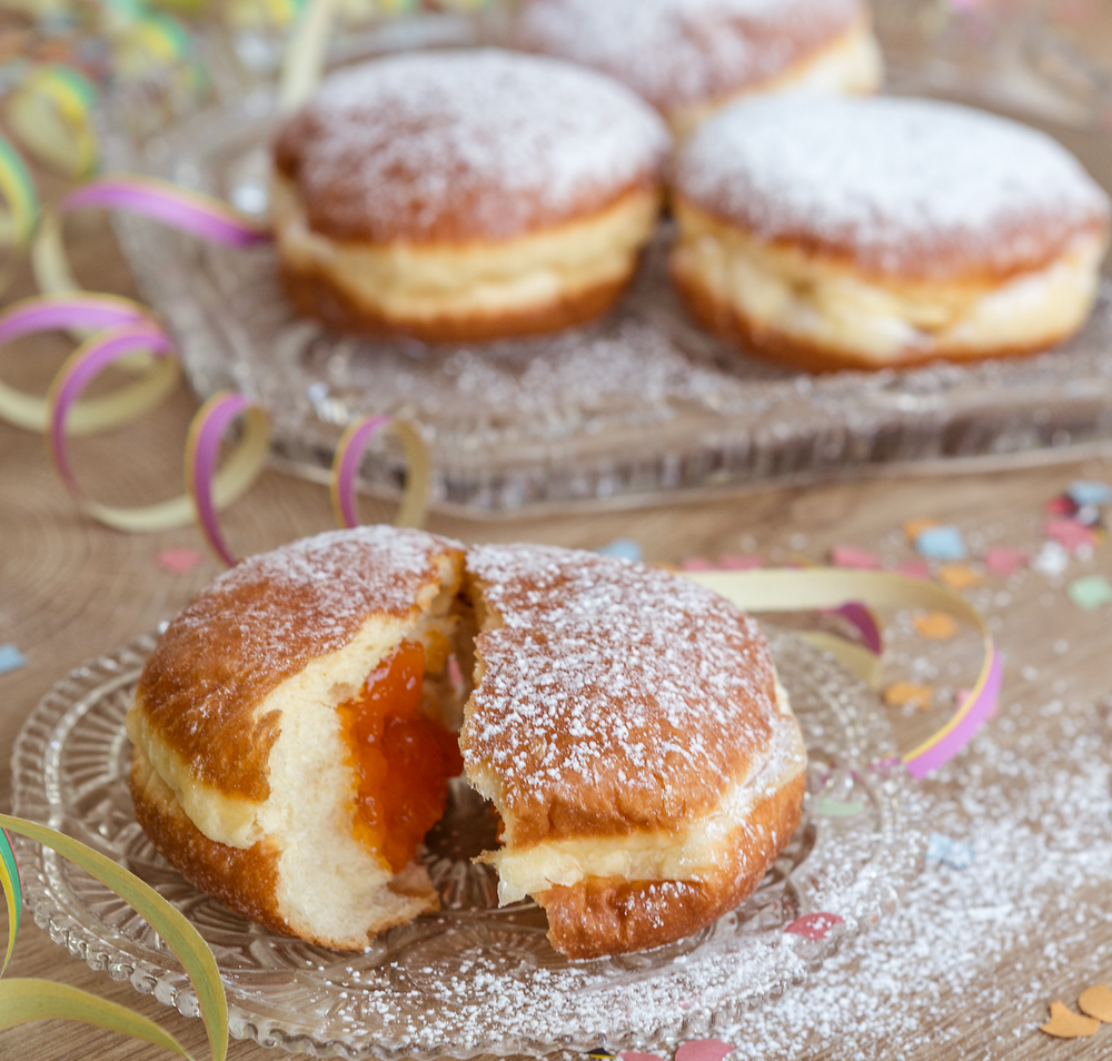 Die köstlichen Faschingskrapfen, mit einer zarten Puderzucker-Schicht bestäubt, laden zum Genießen ein. Umgeben von bunten Konfetti und fröhlichen Feierlichkeiten, versprechen sie süße Momente und unvergessliche Erinnerungen.