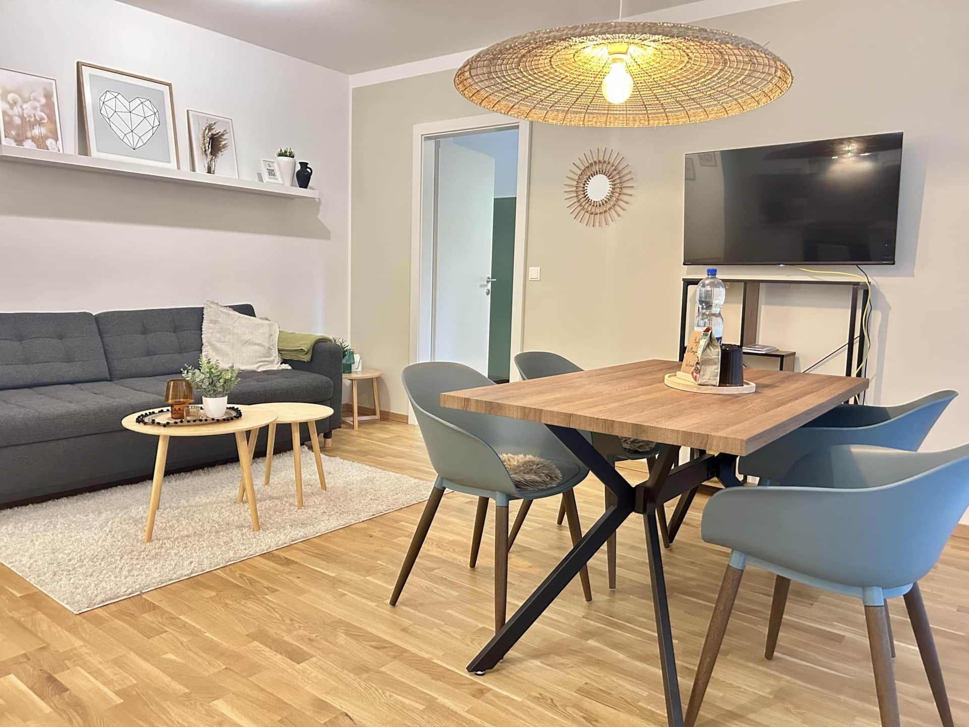 Graue Couch mit Wohnzimmertisch, Esstisch mit bequemen Stoff, Fernseher an der Wand