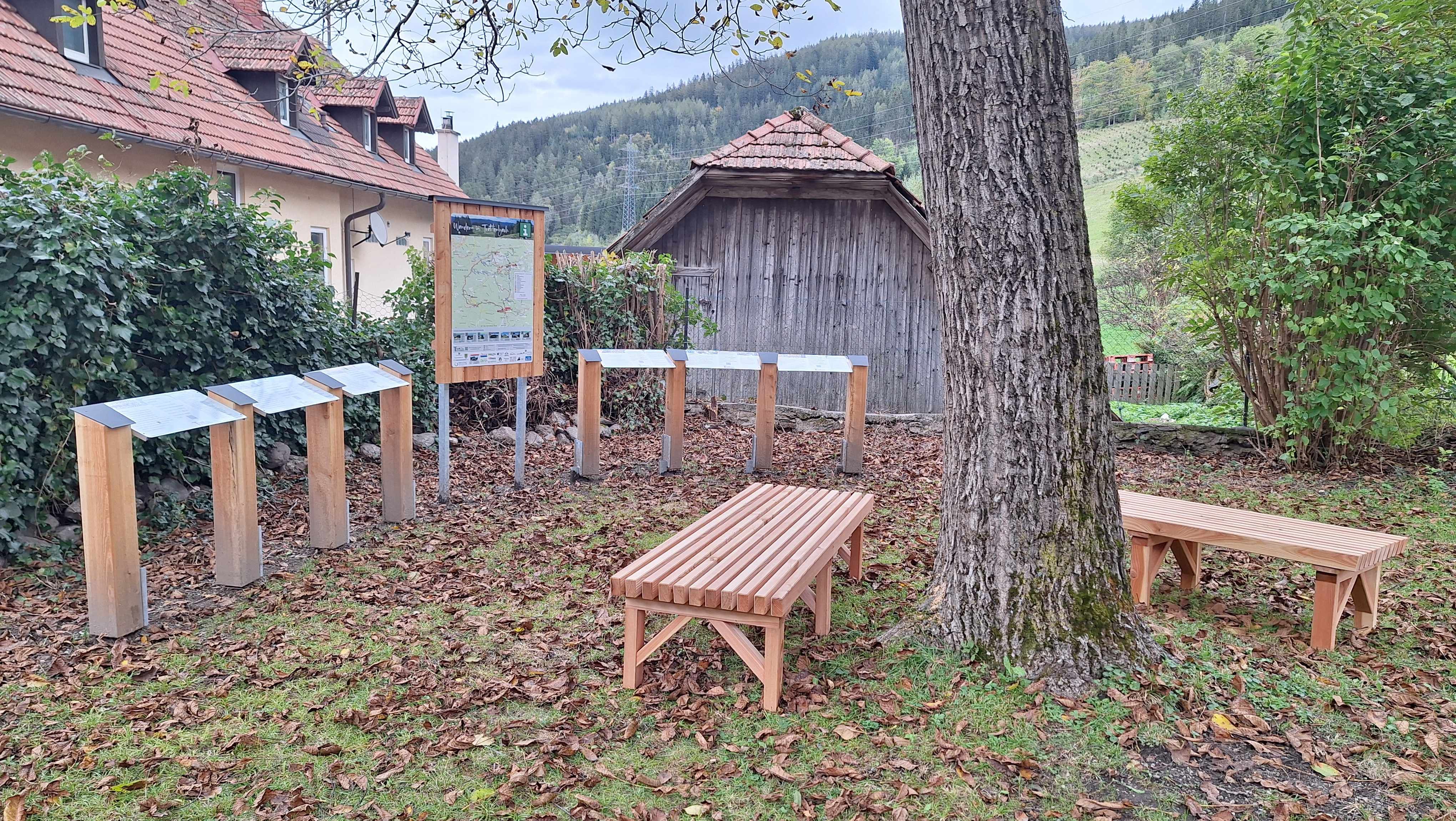 Holzbänke und Informationstafeln im Garten des Wittgensteinhauses.