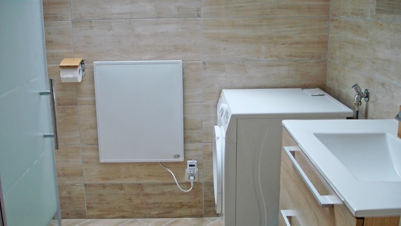 Modern bathroom with washing machine and washbasin.