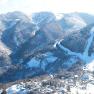 Aerial view of snow-covered mountains and a hotel in the Semmering region.