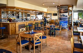 Interior view of a cozy pub with wooden furniture and bar area.