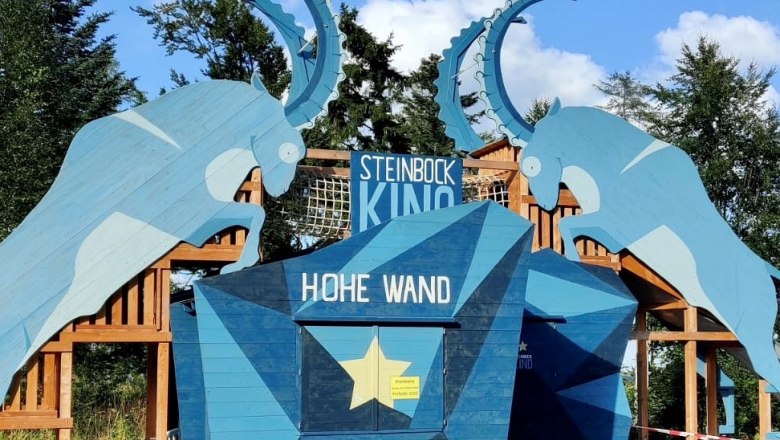 Eingang des Steinbock Kinos im Naturpark Hohe Wand mit blauen Steinbock-Silhouetten.