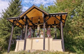 Kalvarienberg mit Kreuzigungsgruppe unter einem überdachten Pavillon.