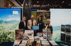 Vier Personen mit dem Schild Wiener Alpen in Niederösterreich hinter Prospektaufstellern 