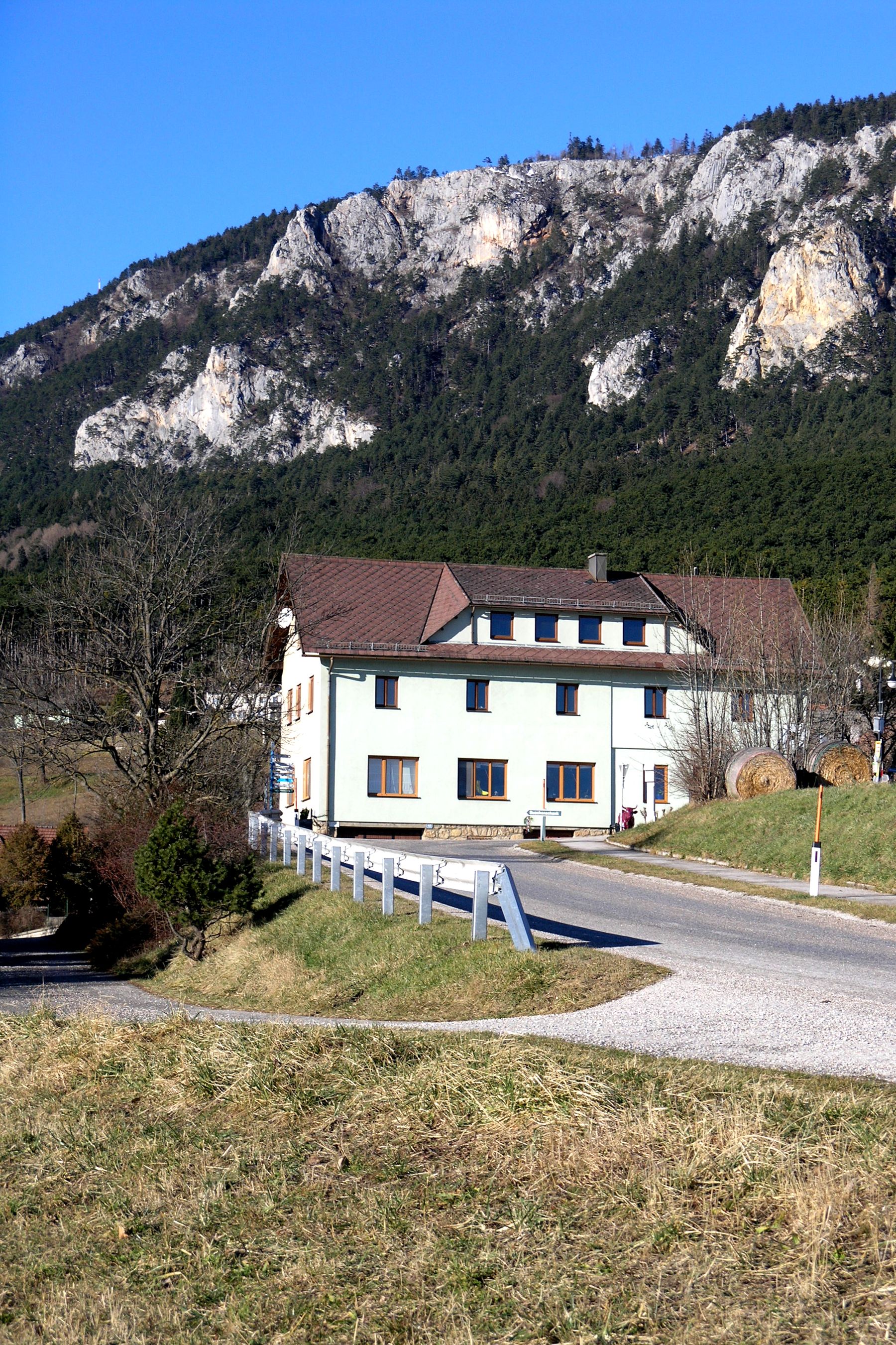 Ein Gebäude vor einer Berglandschaft mit blauem Himmel.